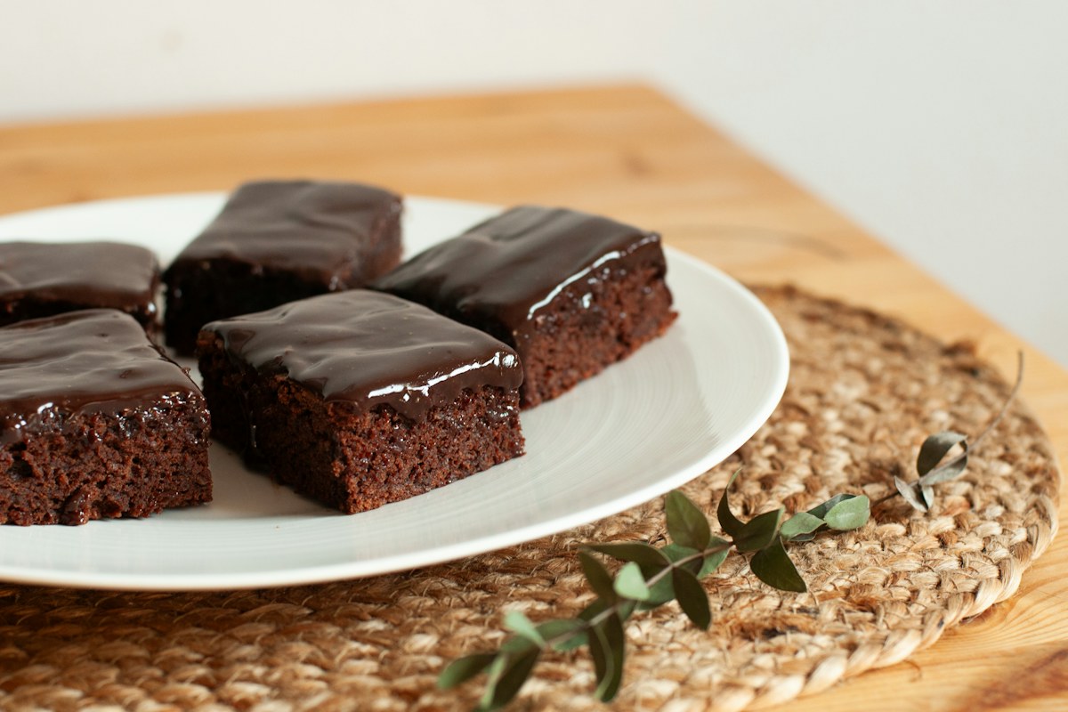Chocolate fudge brownies with glossy ganache on a plate